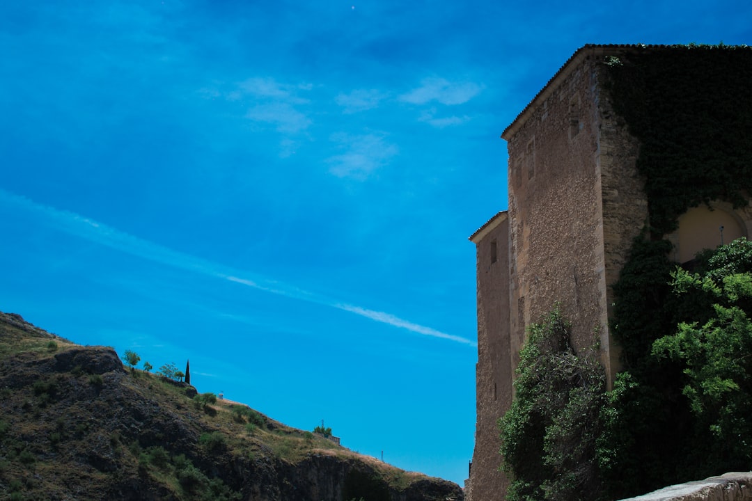 a tall building sitting on top of a lush green hillside,