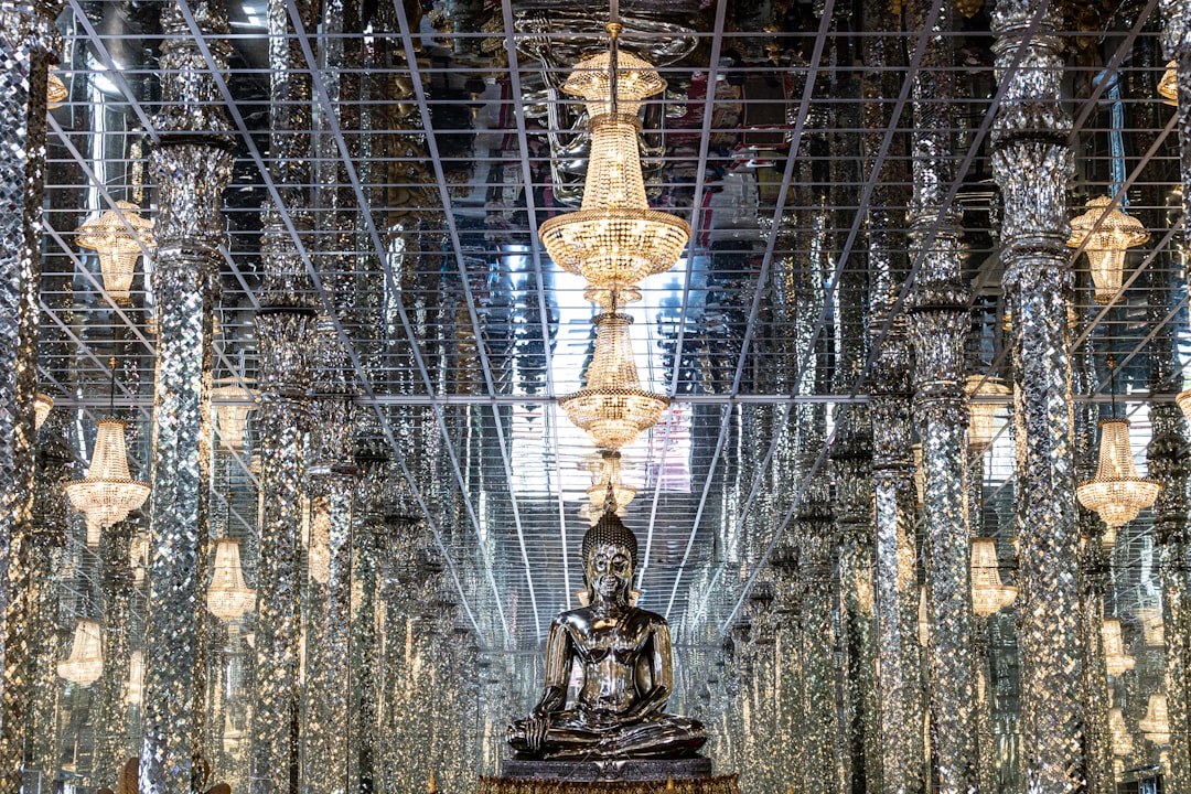 a large buddha statue sitting in a room filled with lots of lights,
