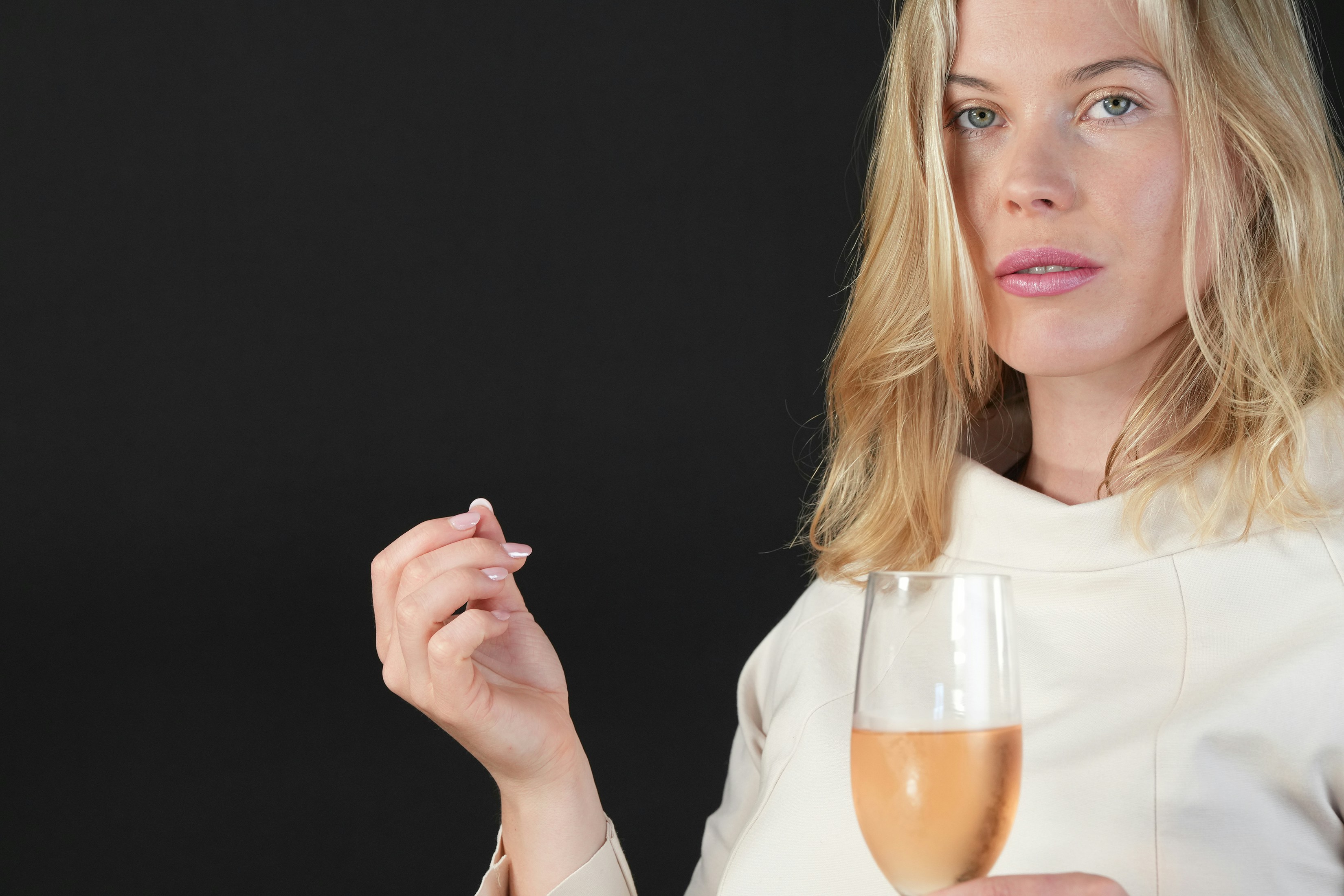 a woman is holding a glass of wine