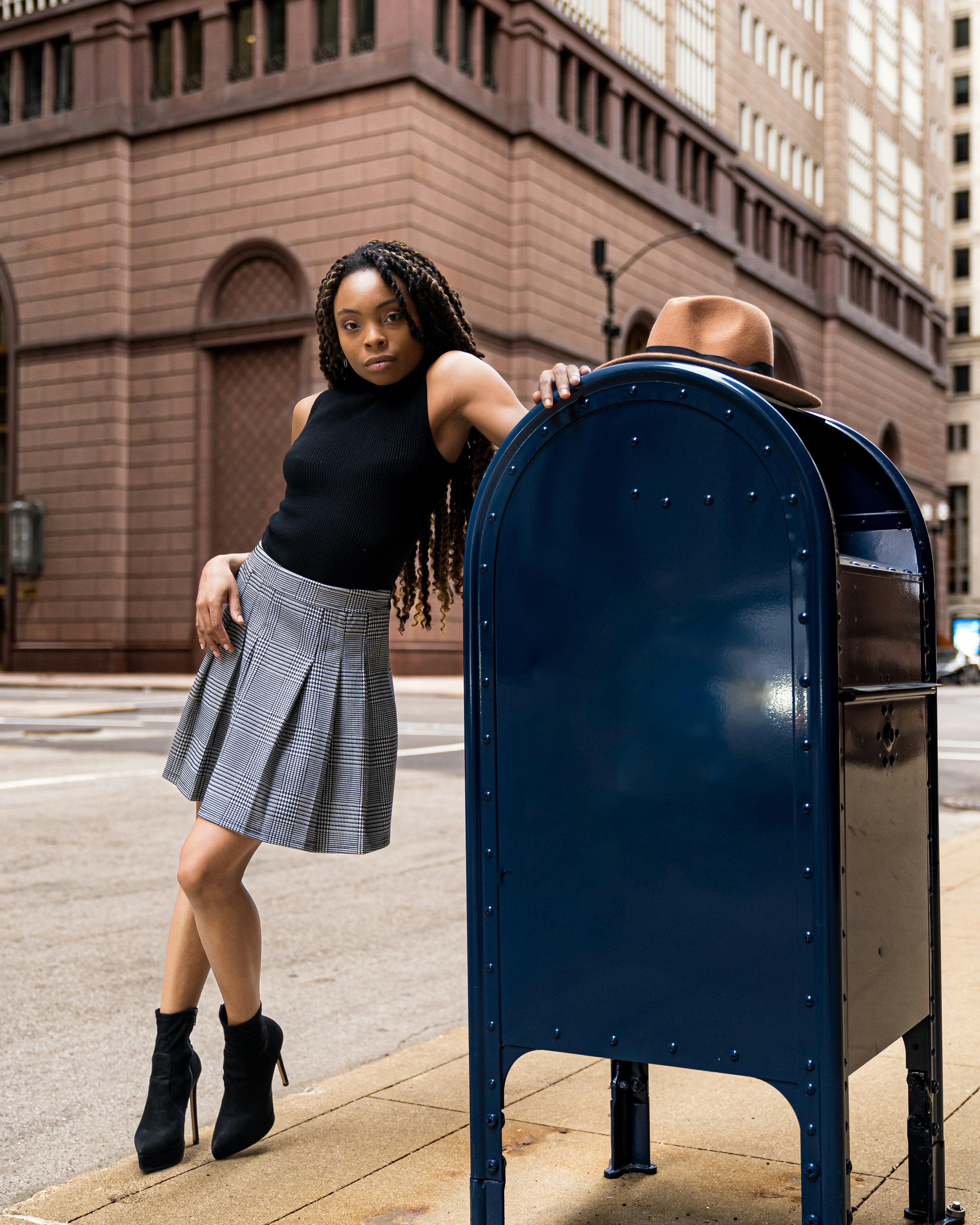 una mujer apoyada en un cubo de basura azul