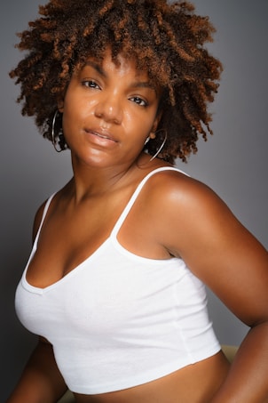 a woman in a white tank top posing for a picture