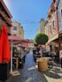 a cobblestone street lined with tables and umbrellas