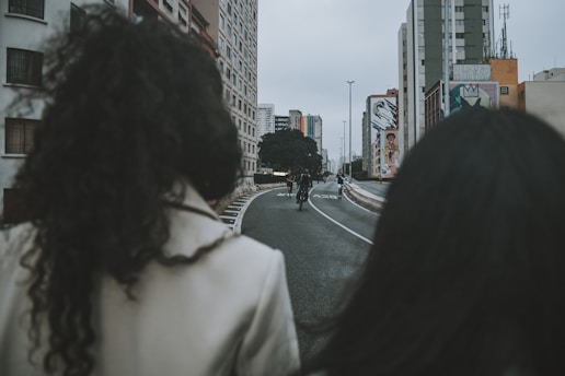 a couple of people riding bikes down a street