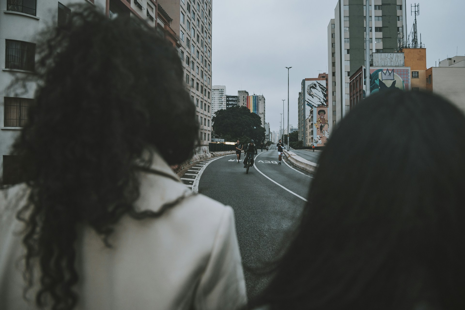 a couple of people riding bikes down a street