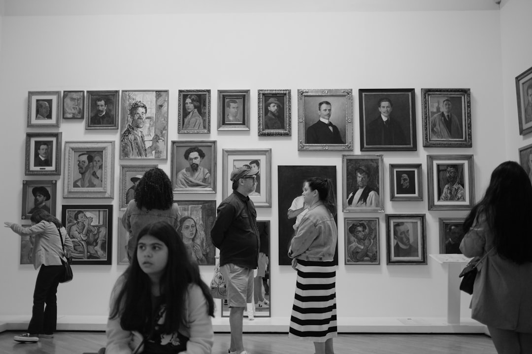 a group of people standing in front of a wall with pictures on it,