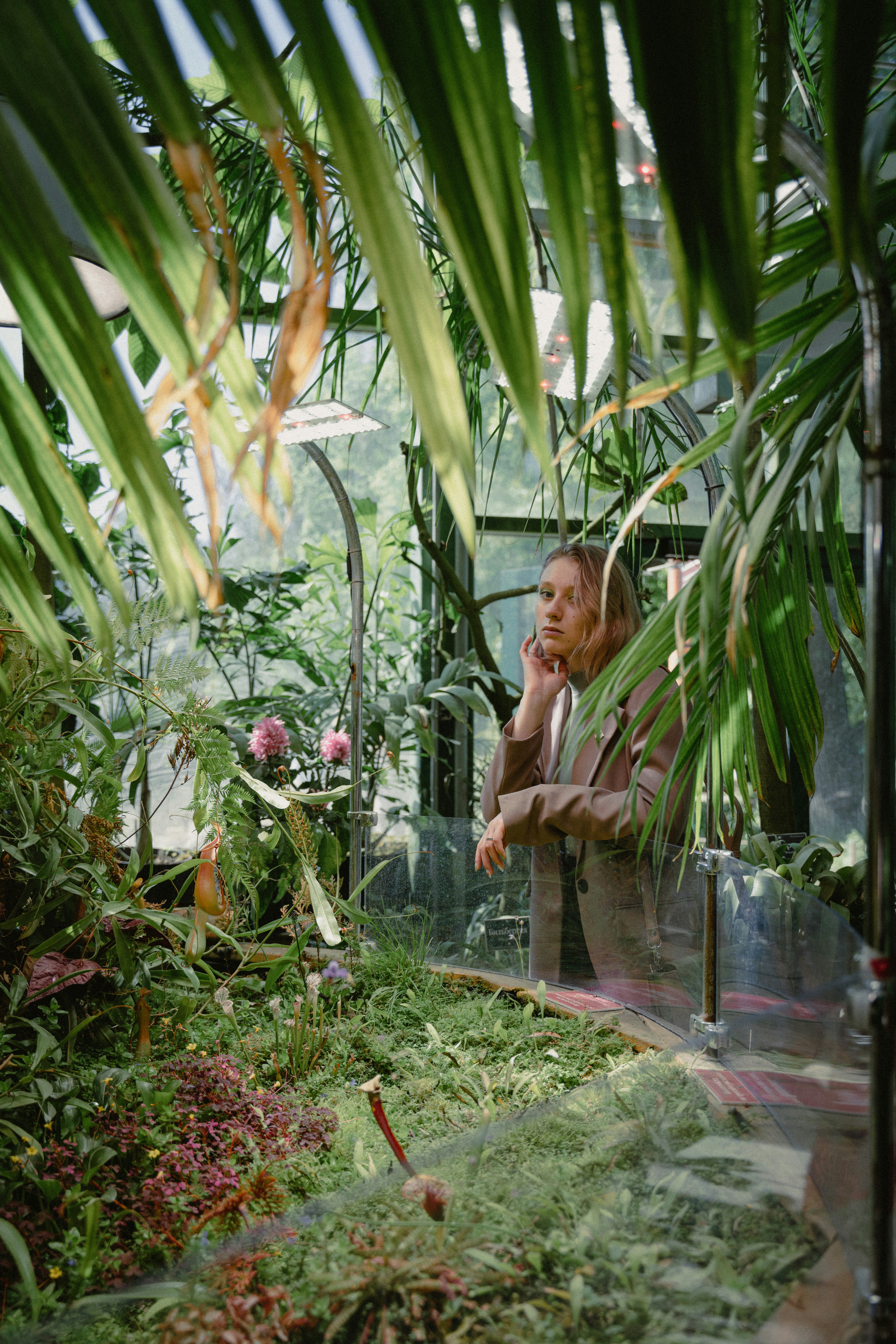 a woman talking on a cell phone in a greenhouse