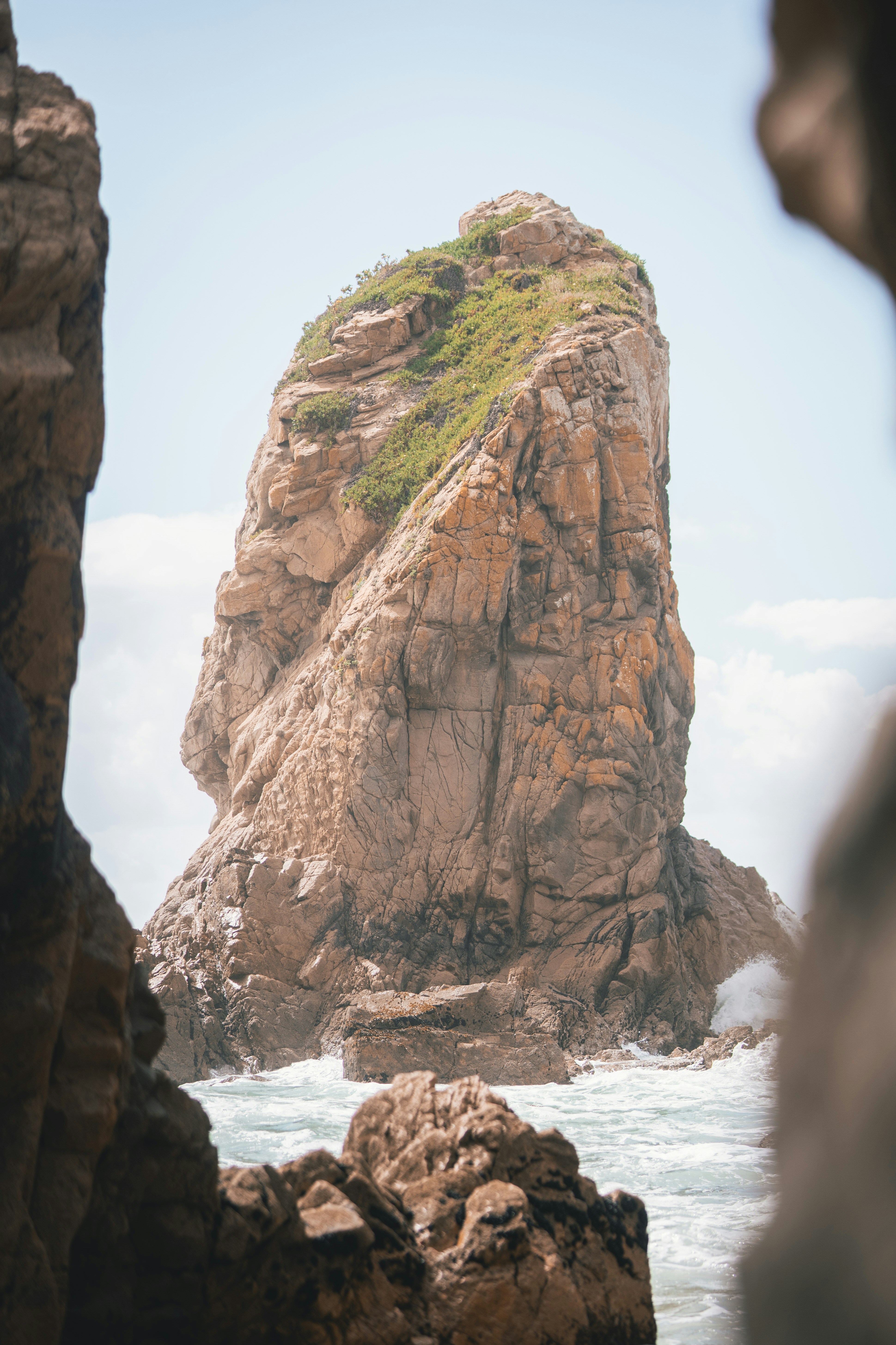 a large rock sticking out of the ocean