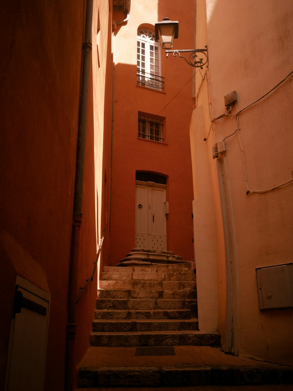 a narrow alleyway with steps leading to a door