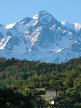 a snow covered mountain with a house in the foreground