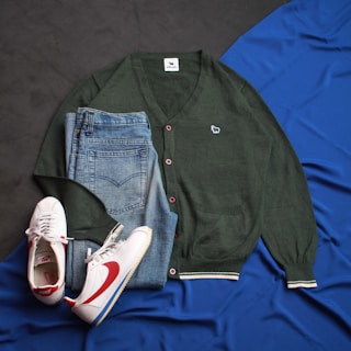 a pair of shoes, a sweater, and a pair of jeans lay on a