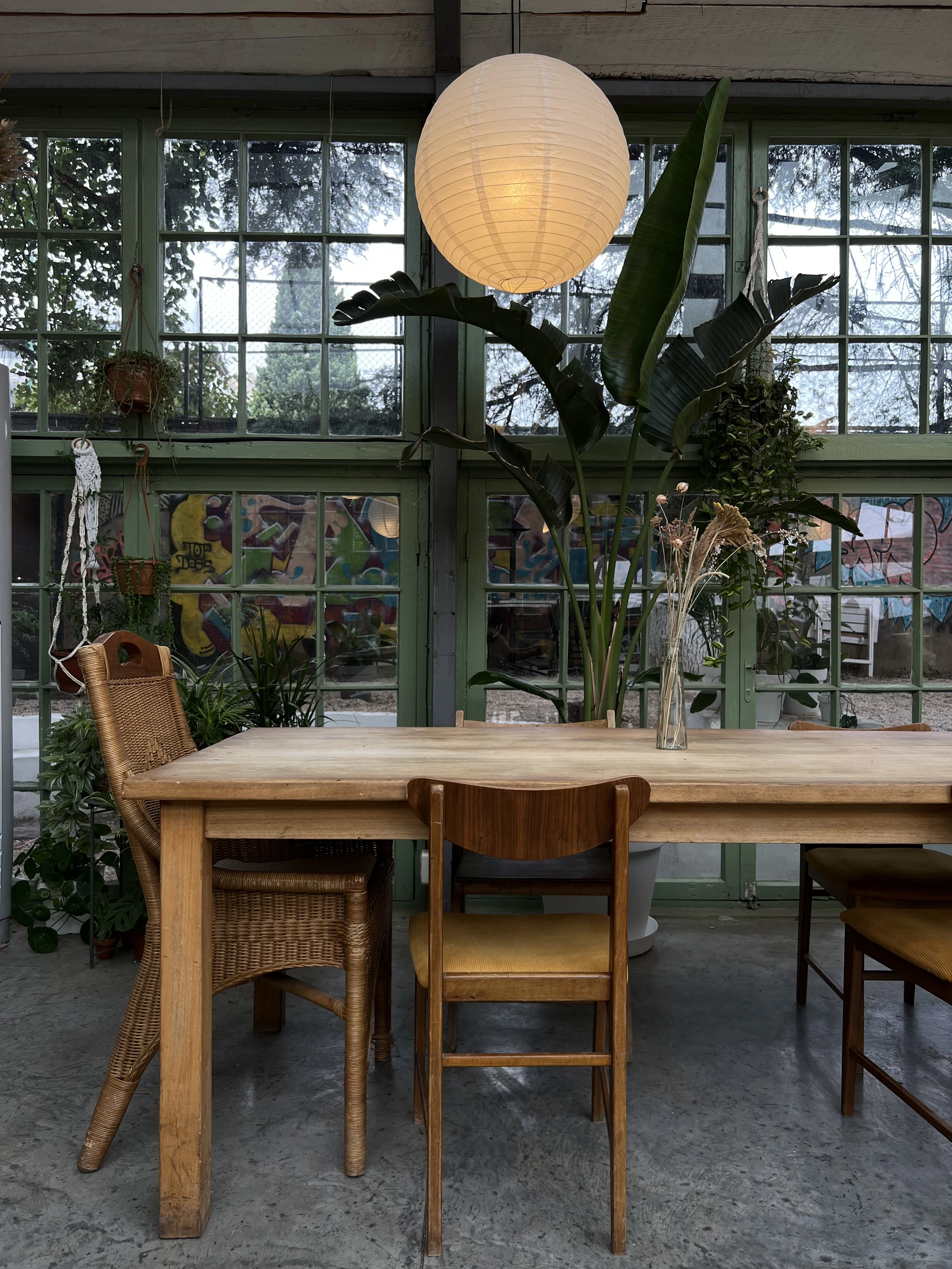 a table and chairs in a room with large windows