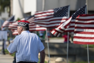 a man standing in front of a row of american flags
