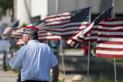 a man standing in front of a row of american flags
