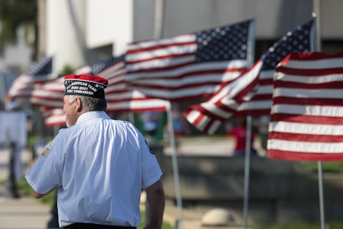 A man standing in front of a row of American flags