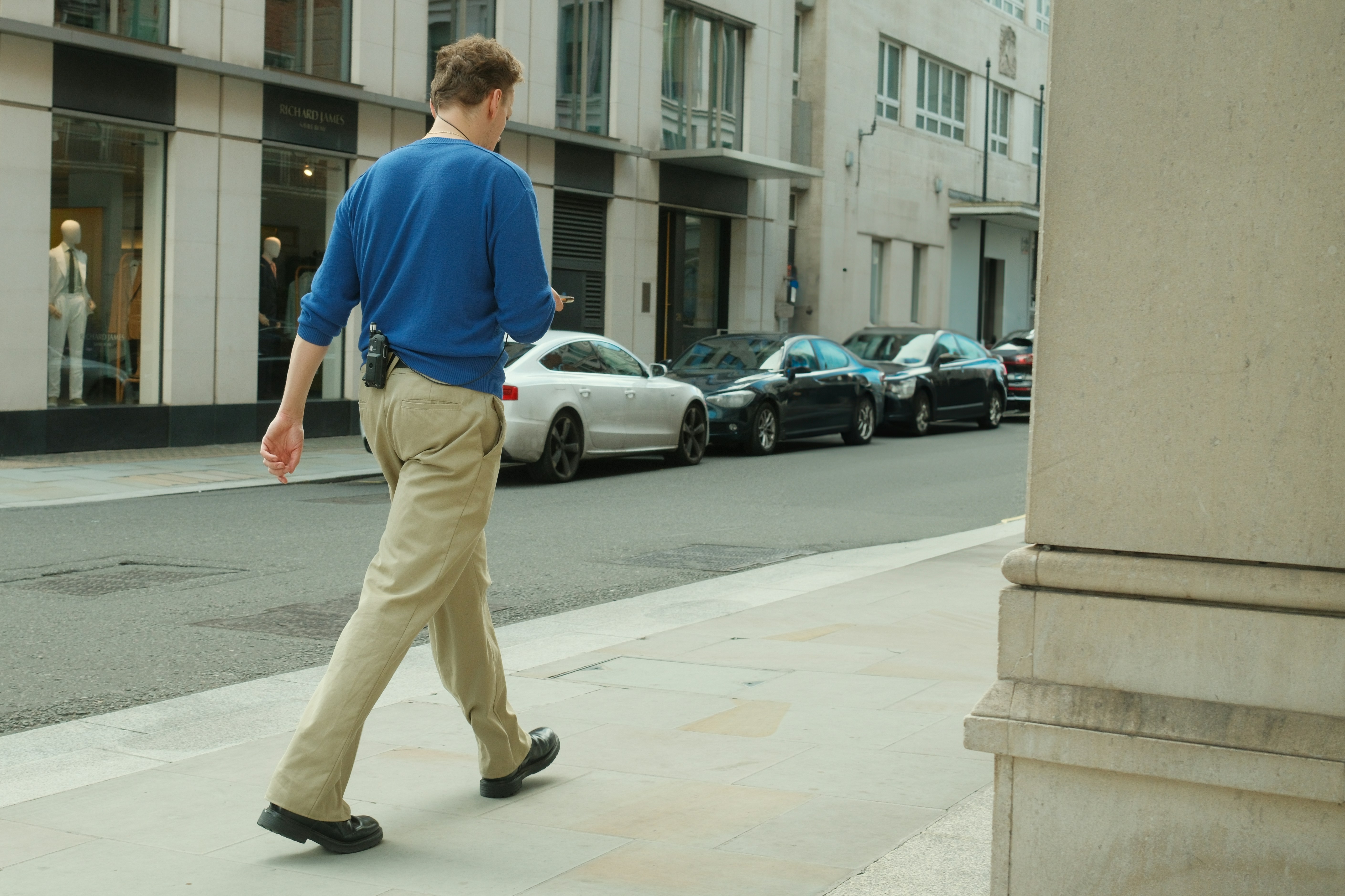 un homme marchant dans la rue en pull bleu