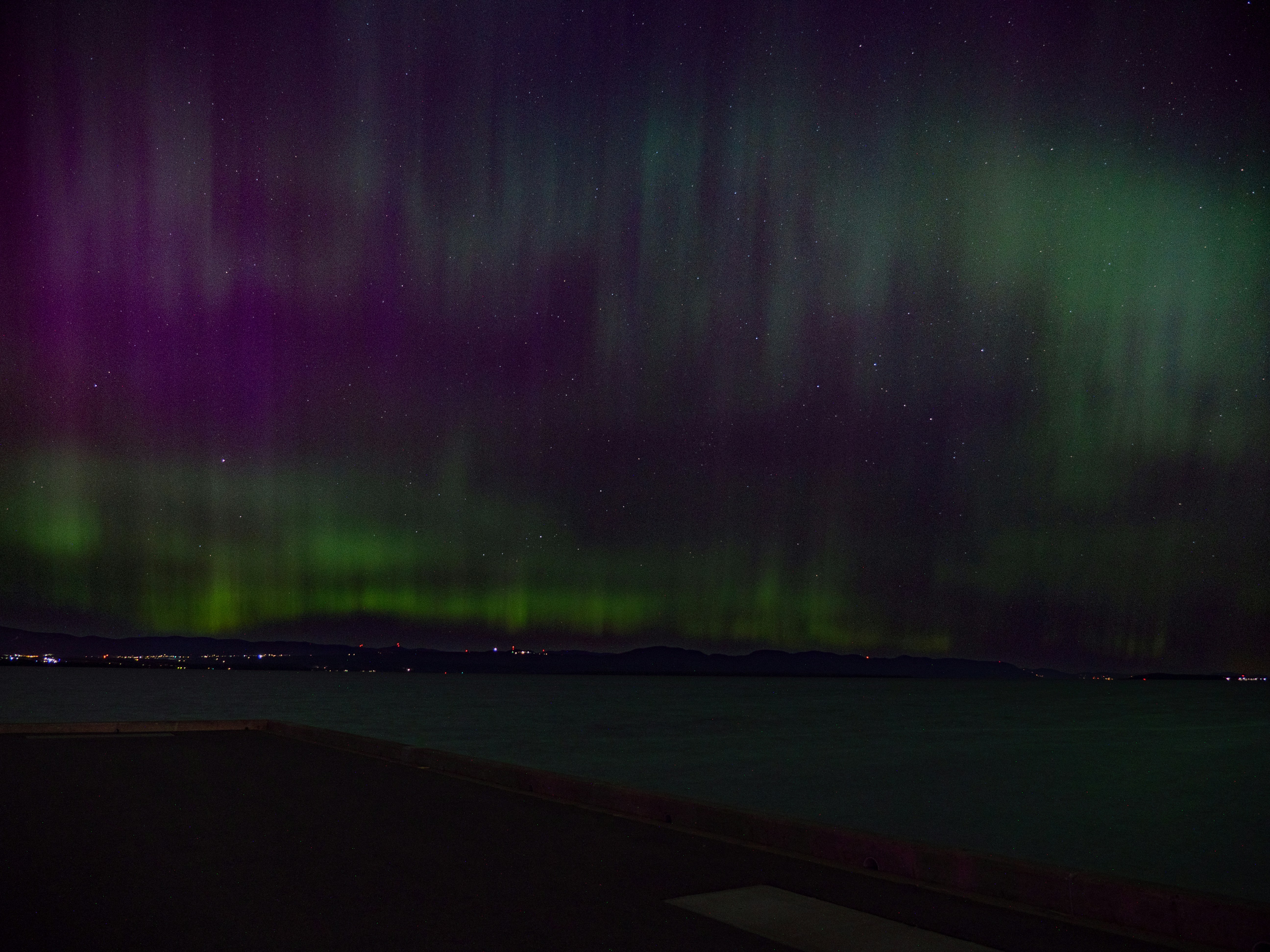 the aurora bore is visible in the sky above a body of water