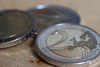 a two euro coin sitting on top of a wooden table