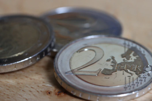 a two euro coin sitting on top of a wooden table