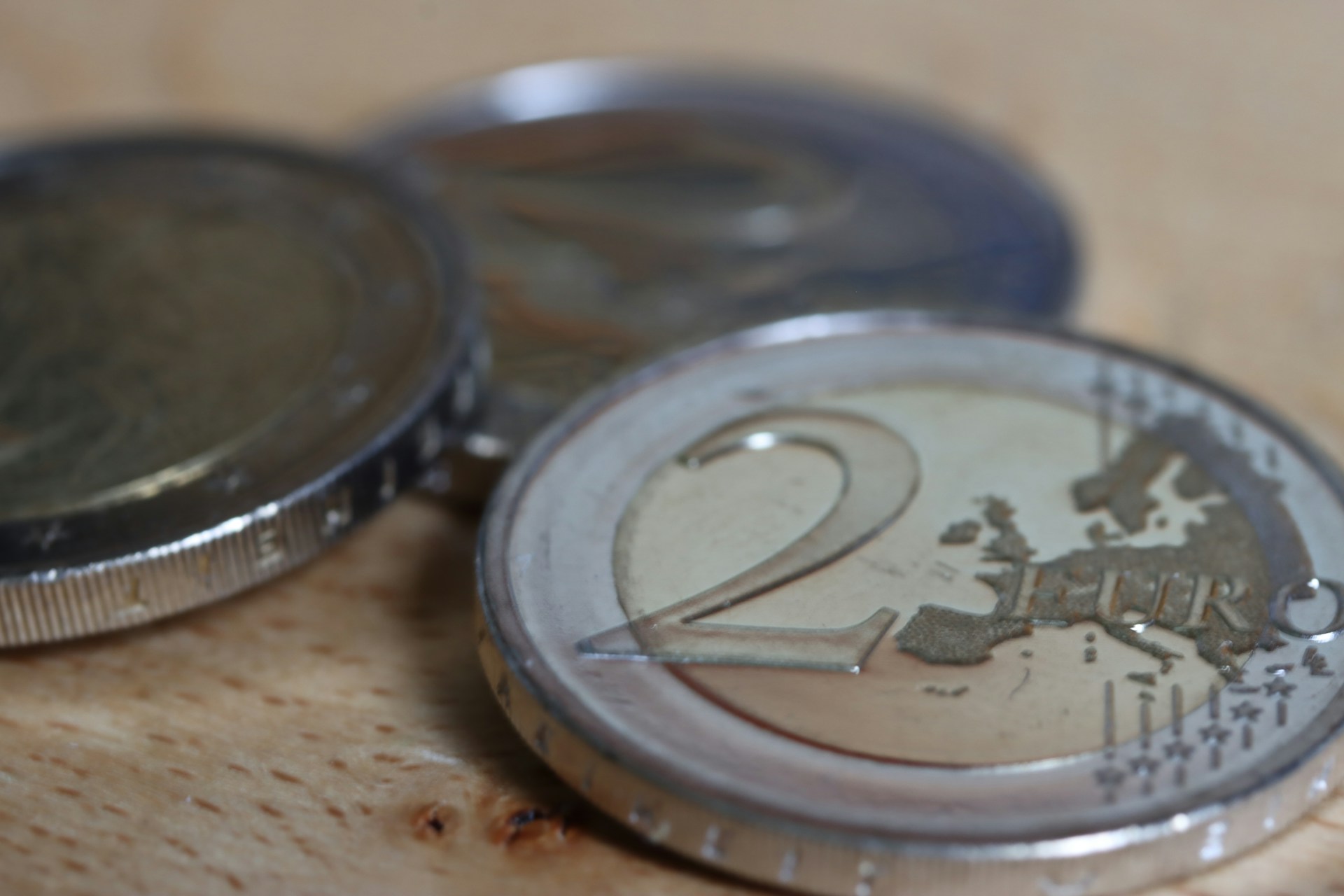 a two euro coin sitting on top of a wooden table
