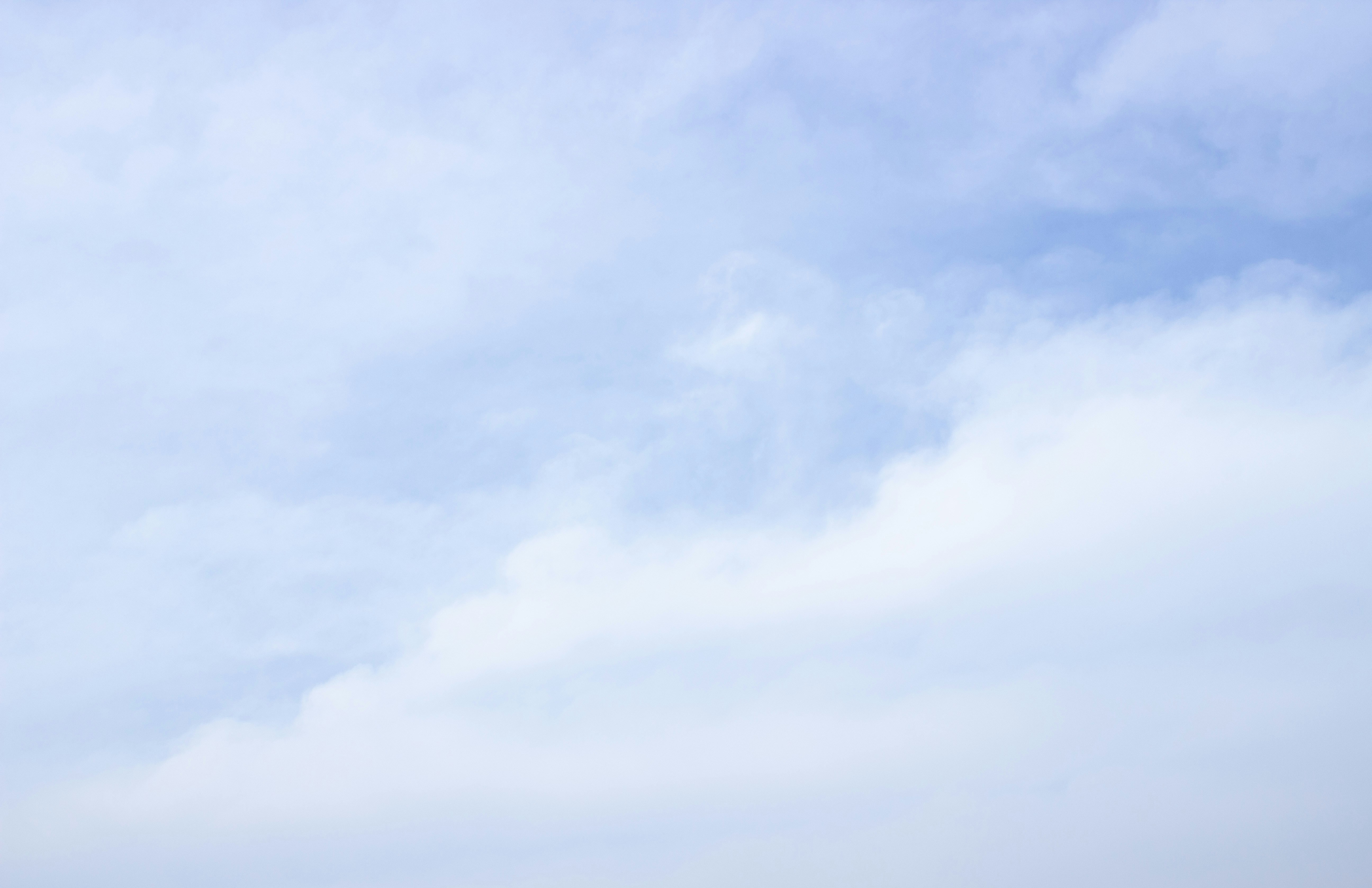 a group of people standing on a beach flying a kite