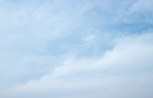 a group of people standing on a beach flying a kite