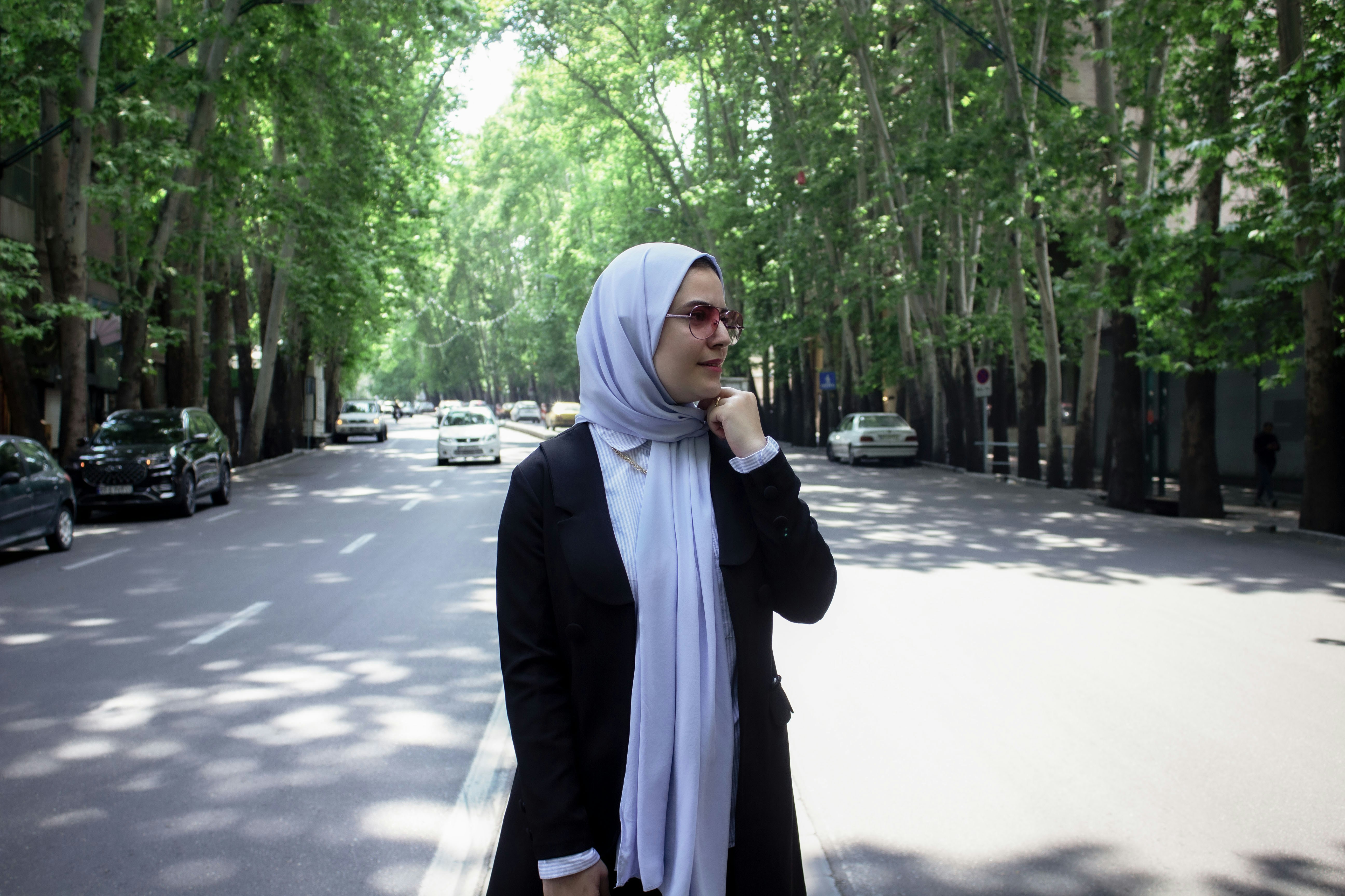 A woman in a hijab is standing on the street photo – Free Photo ...