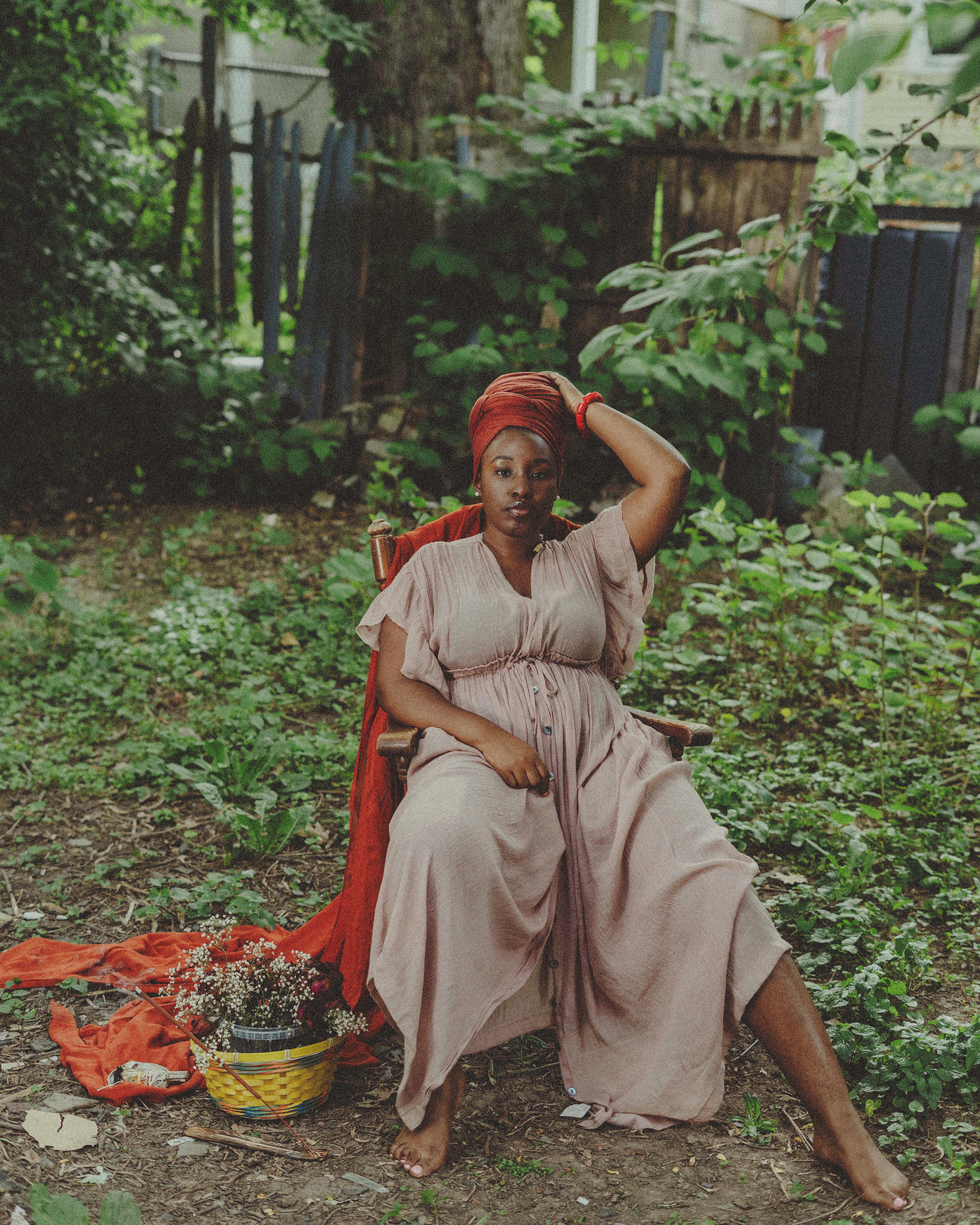 a woman sitting on a chair in a garden