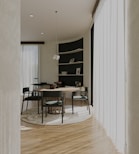 a dining room with a round table and chairs