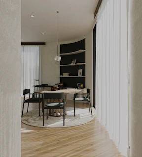 a dining room with a round table and chairs