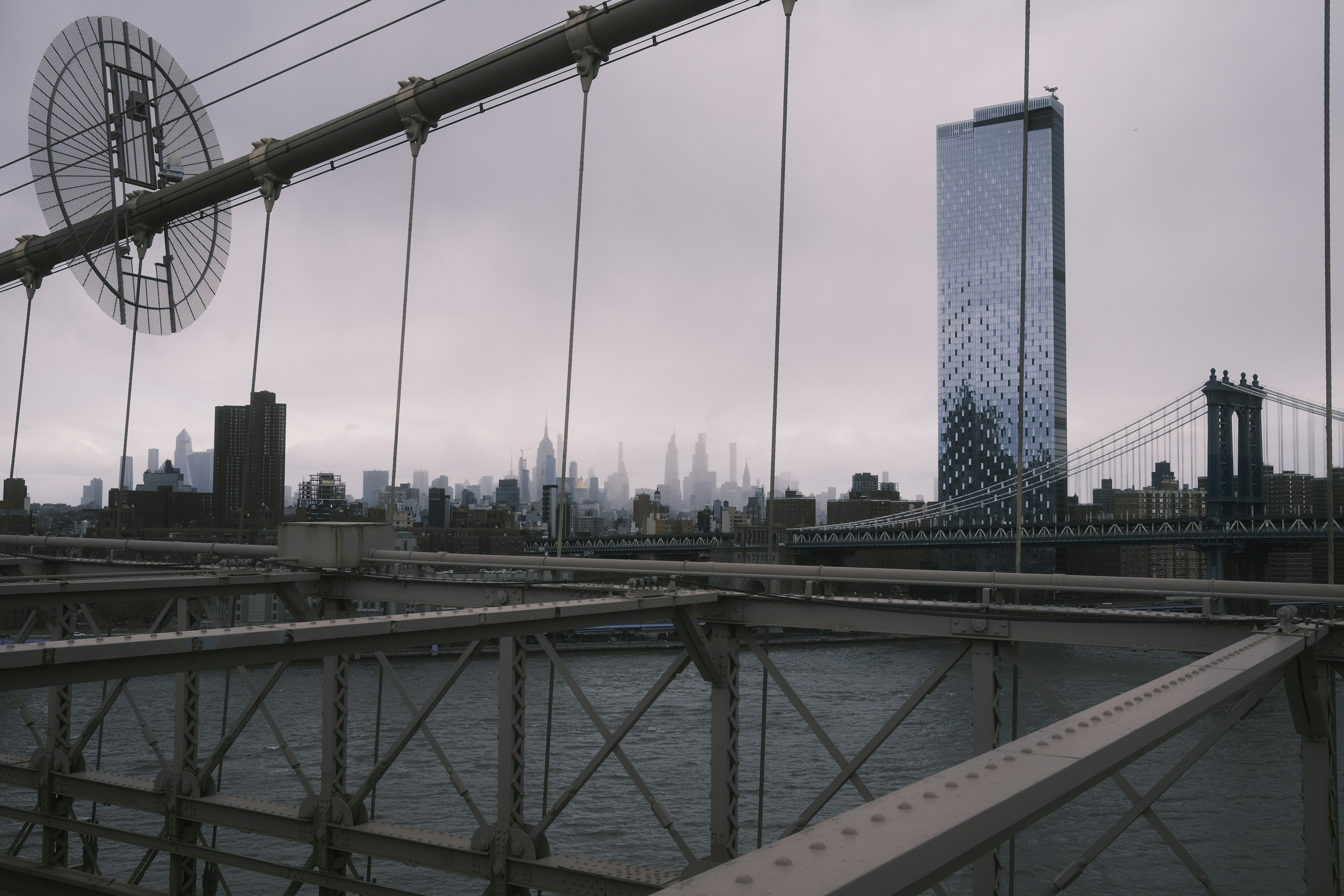 a view of a bridge with a very tall building in the background