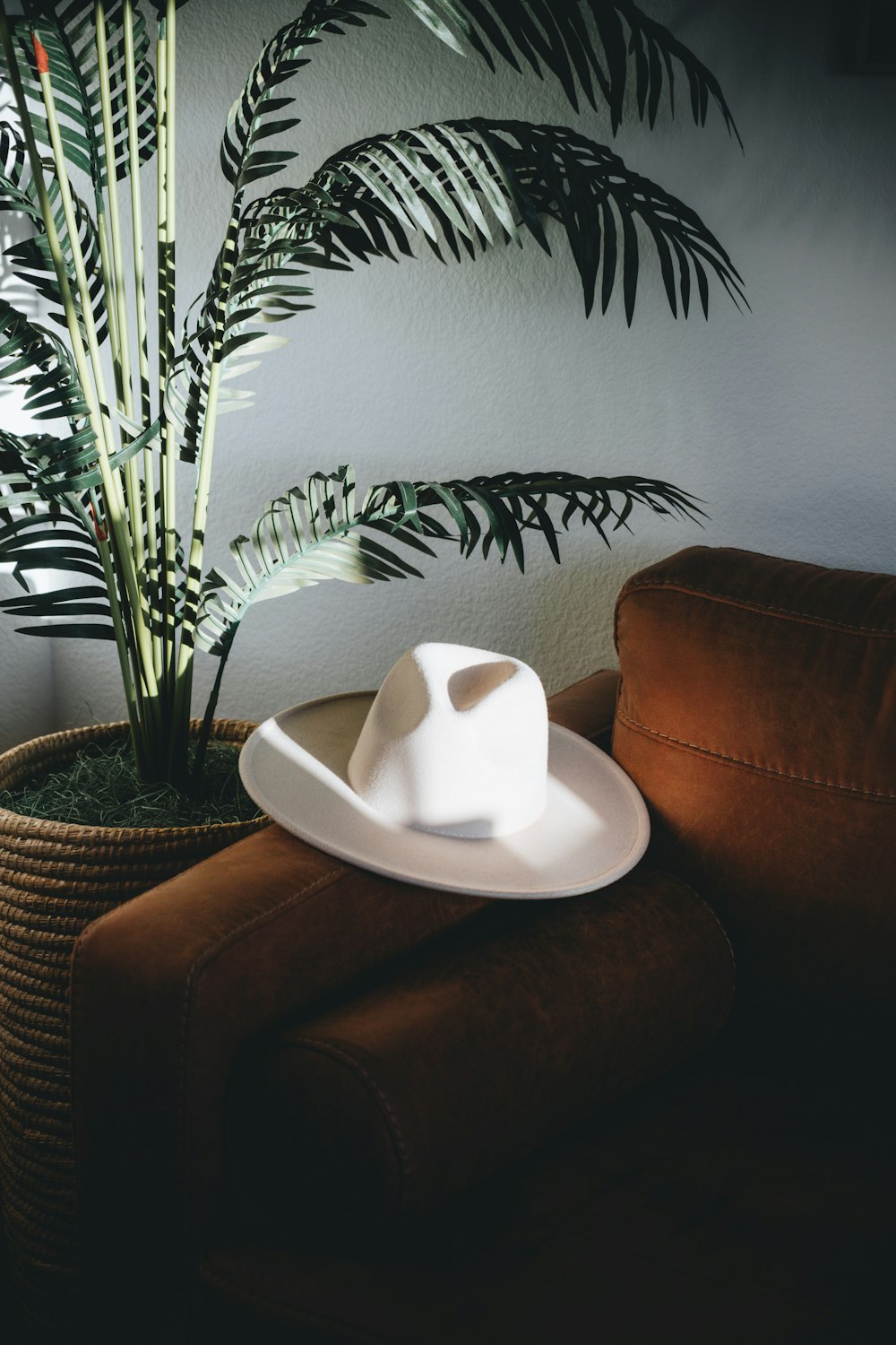 a white hat sitting on top of a brown chair