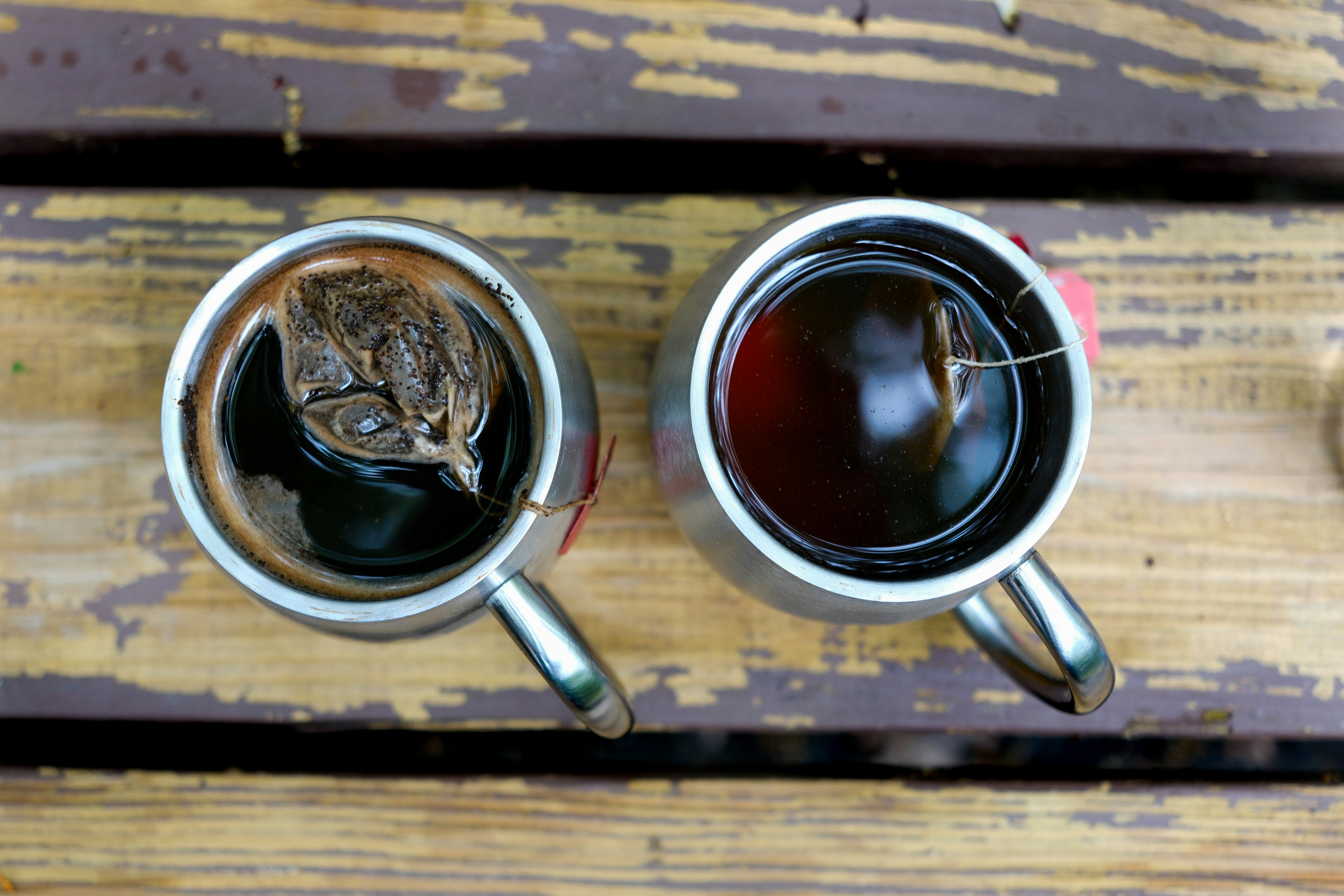 two cups of coffee sitting on top of a wooden table