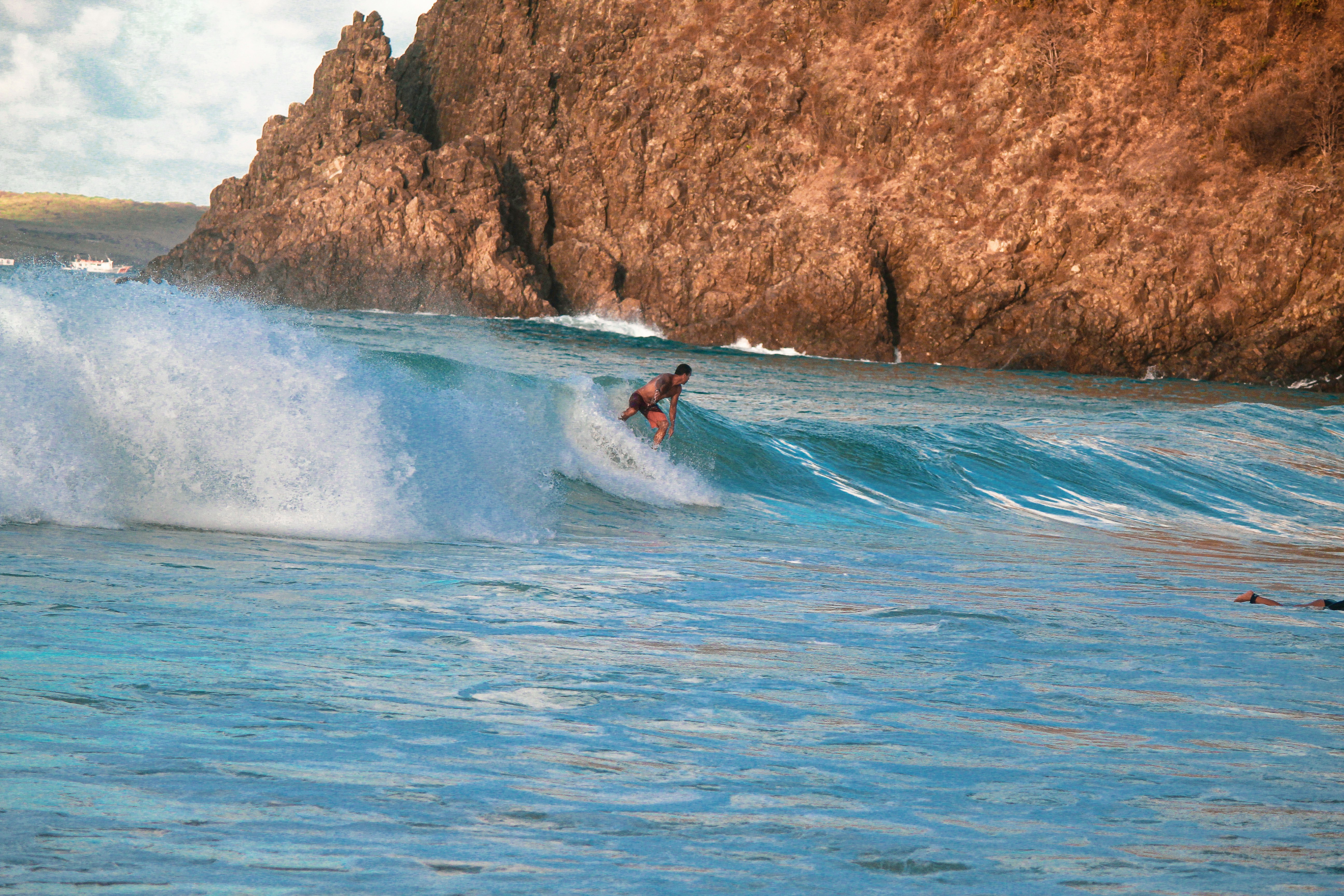 a man riding a wave on top of a surfboard