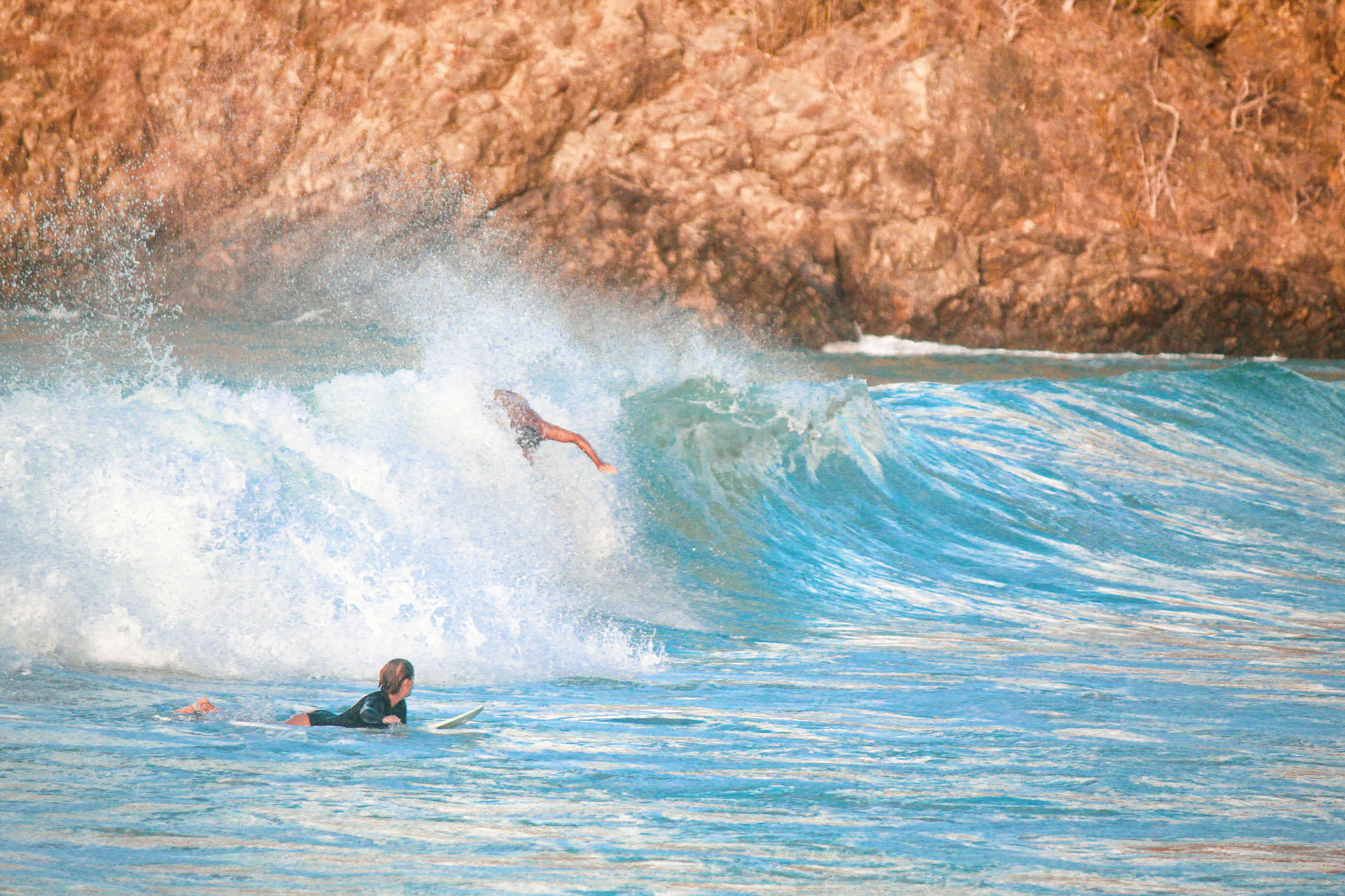 a man riding a wave on top of a surfboard