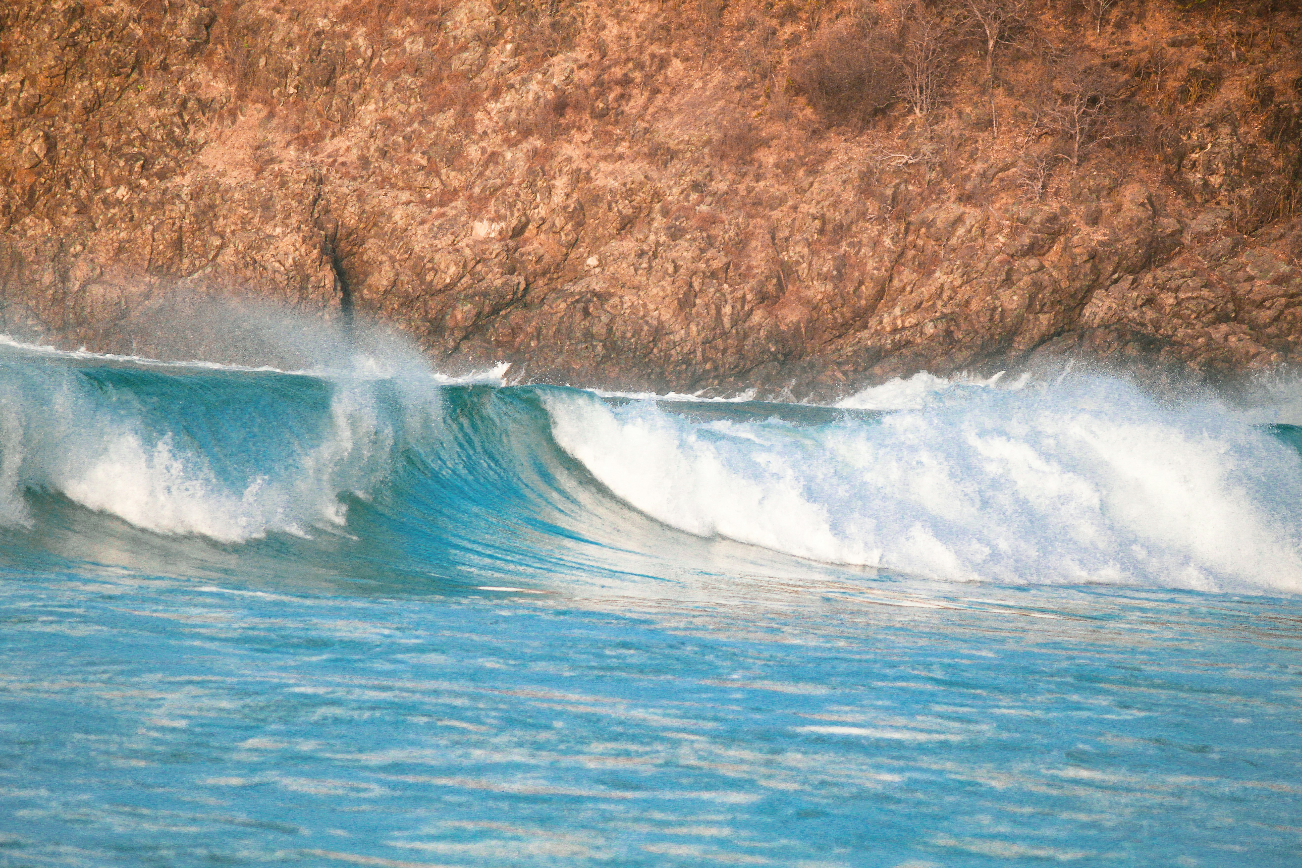 a man riding a wave on top of a surfboard