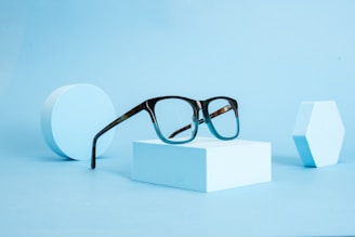 a pair of glasses sitting on top of a white box