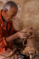a man is making a vase out of clay