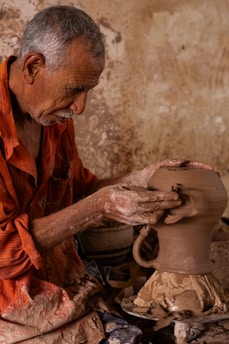 a man is making a vase out of clay