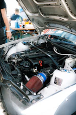 the engine of a car with a man standing next to it