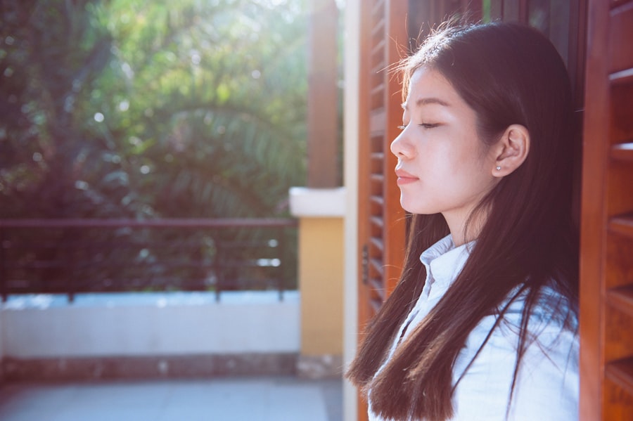 窓辺で朝の光を浴びる女性