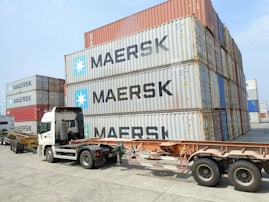 a semi truck is parked next to a large container