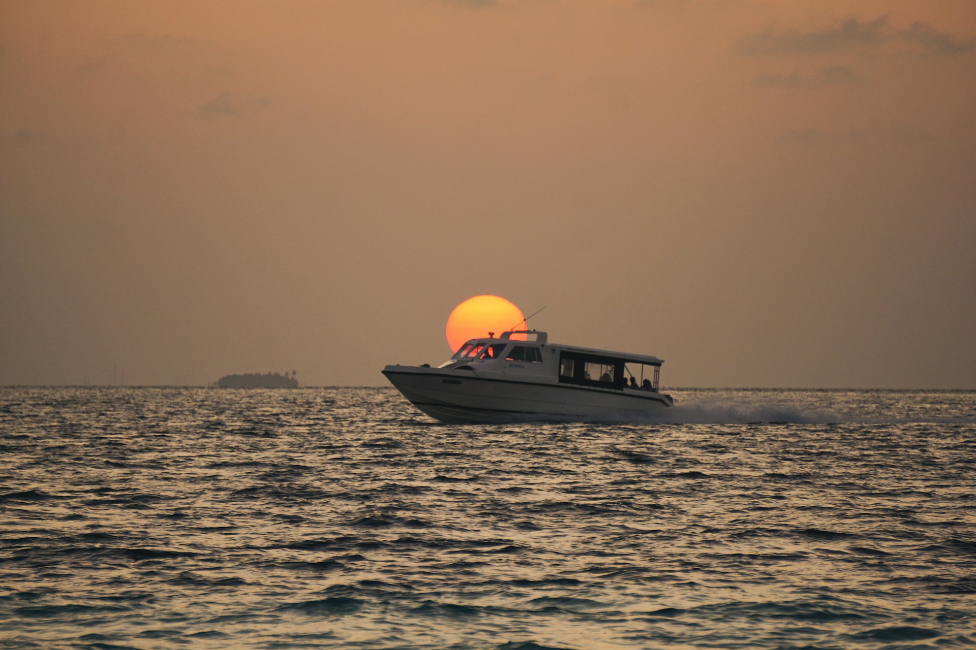 a boat is traveling across the water at sunset