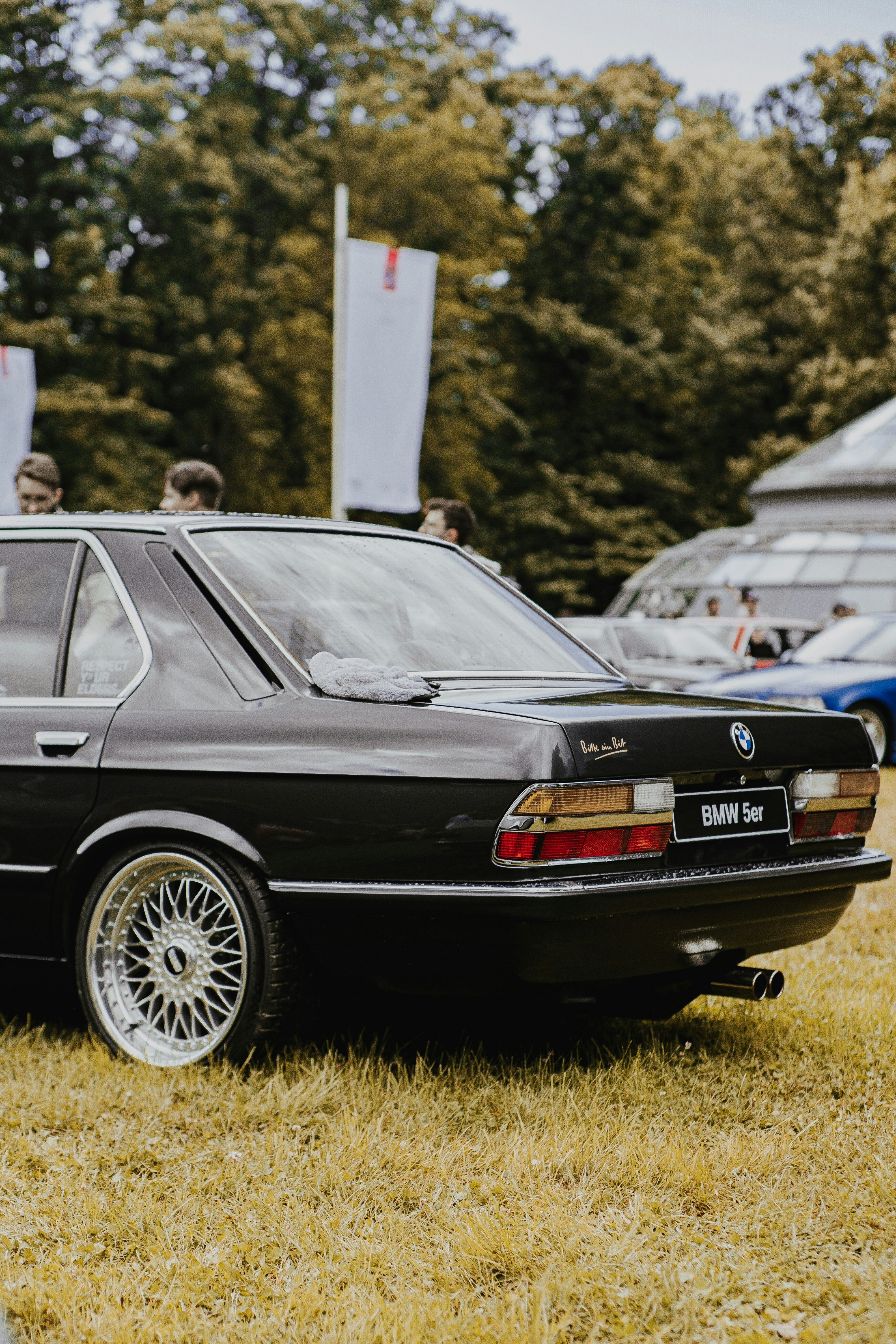 a black car parked on top of a grass covered field