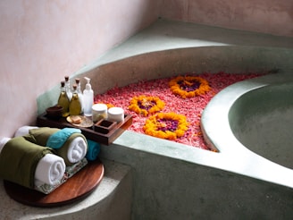 a bath room with a bath tub and a tray of flowers
