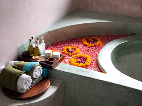 a bath room with a bath tub and a tray of flowers