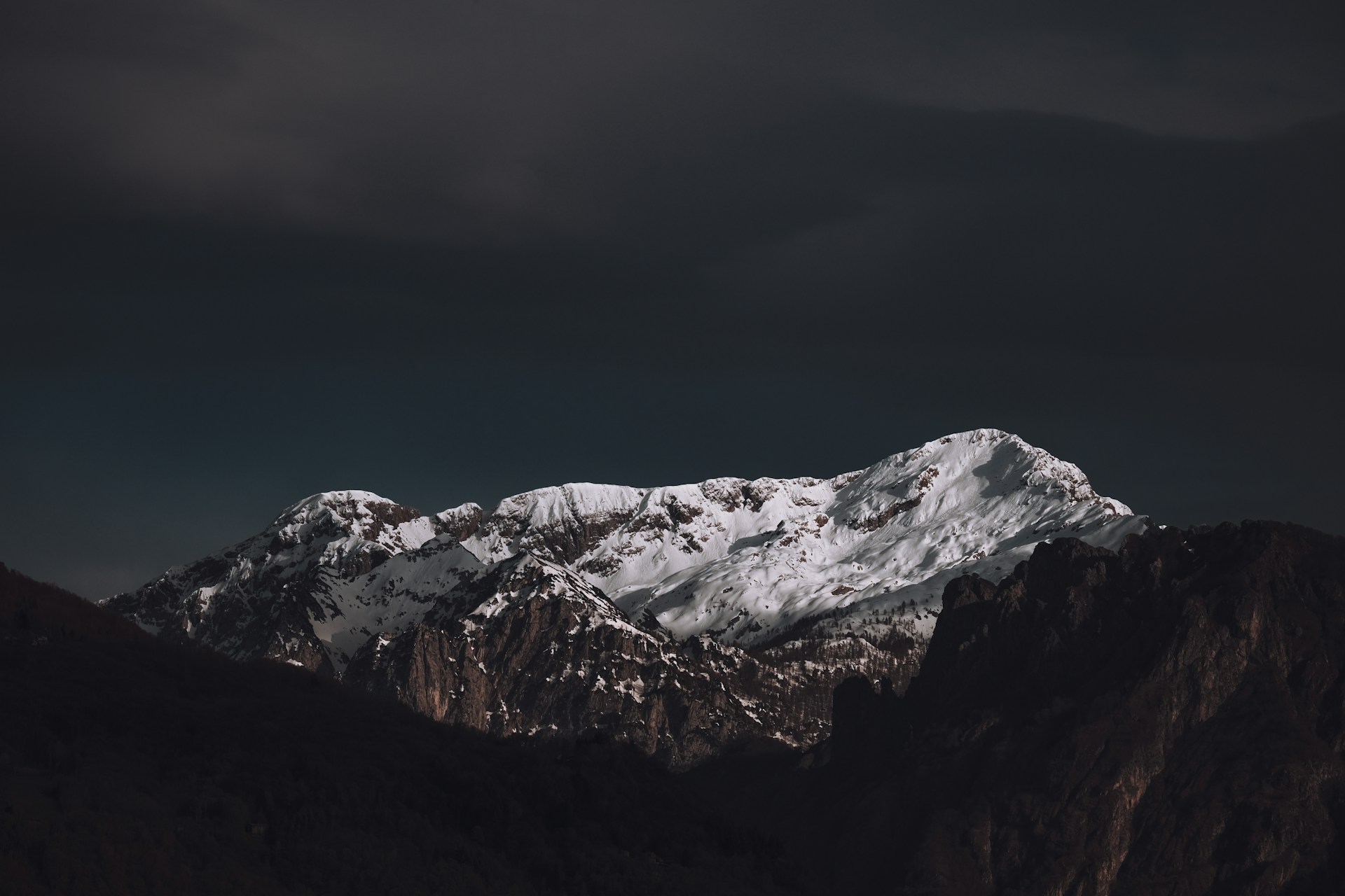 a snow covered mountain under a dark sky