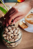 a person putting nuts in a glass bowl