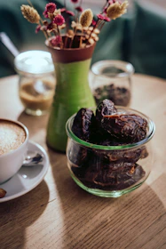 Dried dates in a glass jar on a wooden table