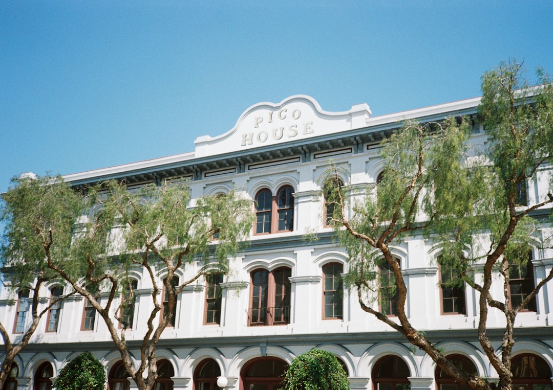 a large white building with trees in front of it,