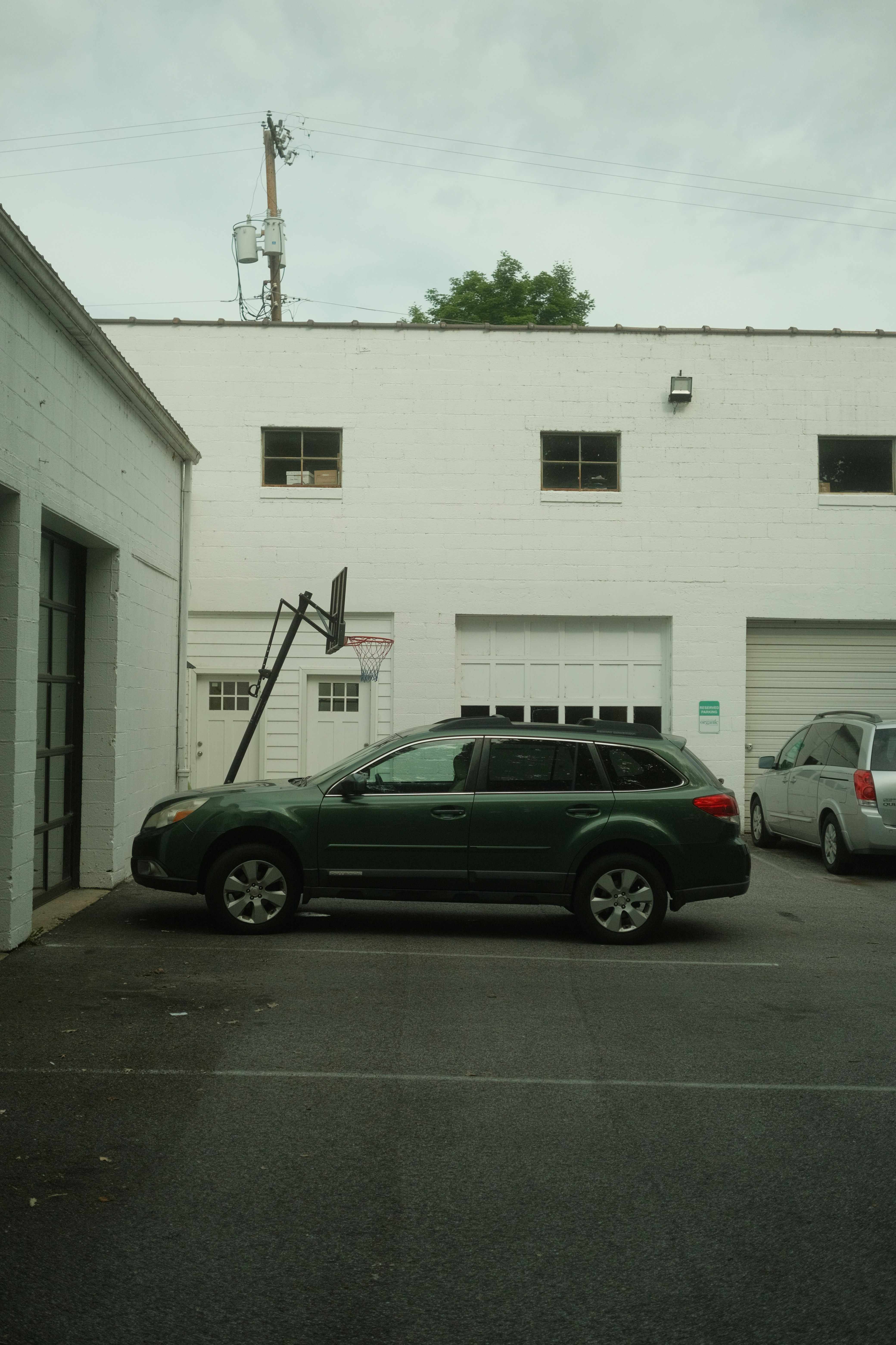 Un coche aparcado en un aparcamiento junto a un edificio